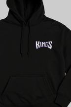 Black hoodie with 'KINGS' text on a beige background