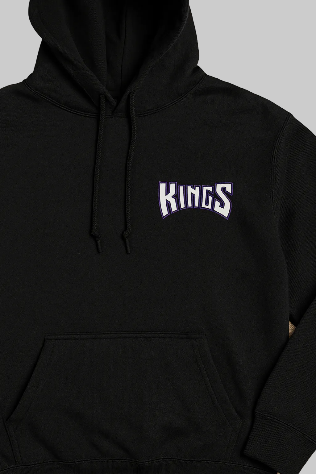 Black hoodie with 'KINGS' text on a beige background